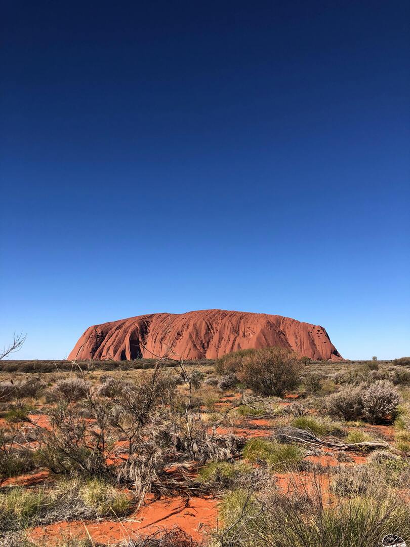 Uluru monolith in desert landscape